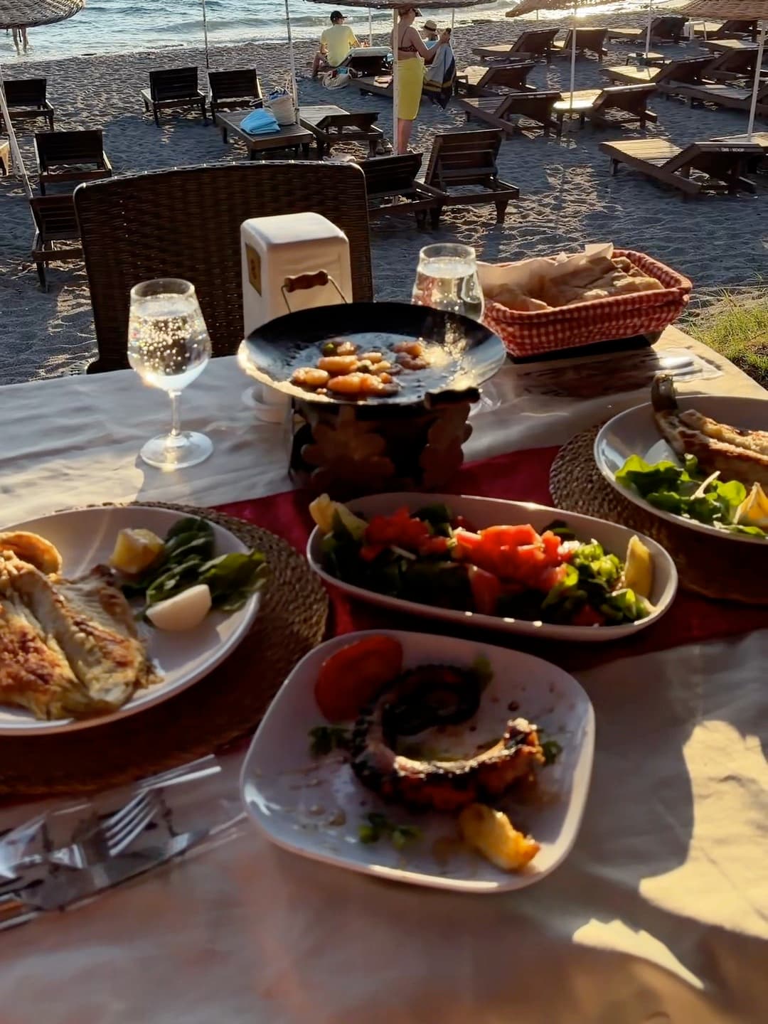 Akşam ışığında kumsalda kurulmuş yemek masası